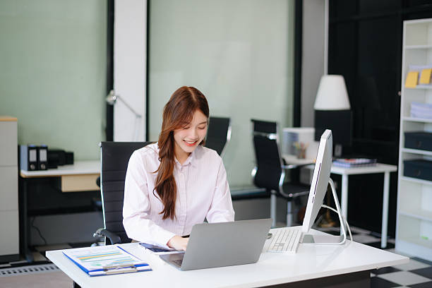 istock Asian woman using laptop and tablet while sitting at her working place. Concentrated 2204060266
