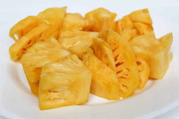 Cut pineapple flesh, on white plate, isolated on white background
