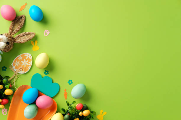 istock Easter layout with Easter bunny, tulips, colorful eggs on green background 2204070557