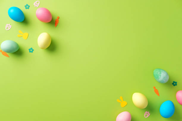 istock Colorful Easter eggs and confetti on bright green background. Flat lay, top view, minimal 2204070593