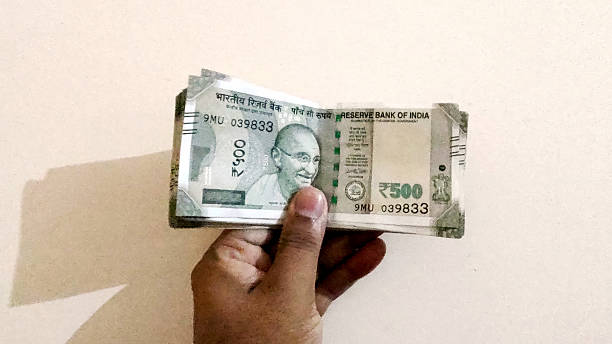 istock Man Hand holding Rupees 500 bank note savings 2204070602