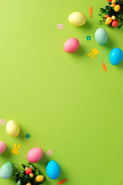 istock Easter vertical background. Top view colorful Easter eggs and festive decorations on green table. 2204070621