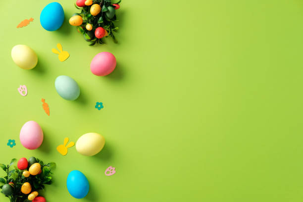 istock Happy Easter background with colorful Easter eggs and confetti on bright green table. 2204070725