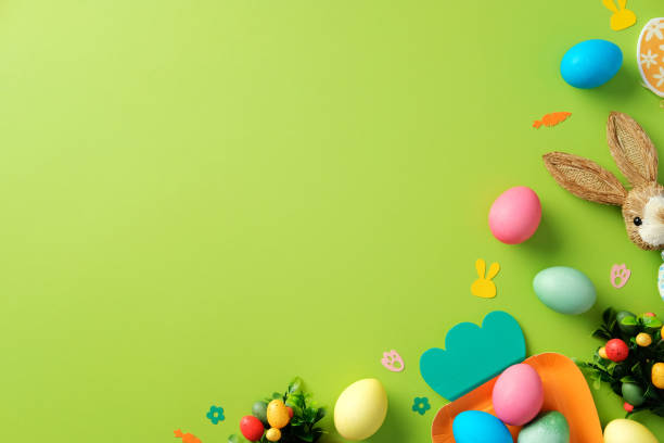istock Happy Easter background. Top view colorful Easter eggs, bunny, and confetti on bright green table. 2204070753