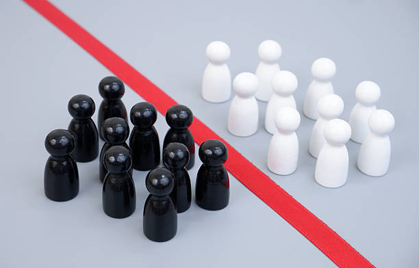 istock Two groups of white and black people figures separated by red line 2204077116