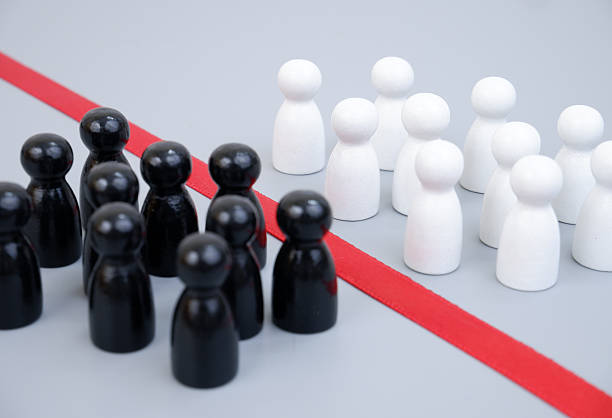 istock Two groups of white and black people figures separated by red line 2204077131