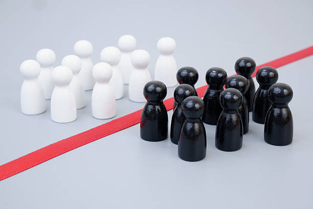 istock Two groups of white and black people figures separated by red line 2204077139