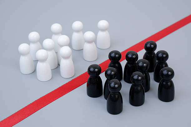 istock Two groups of white and black people figures separated by red line 2204077174