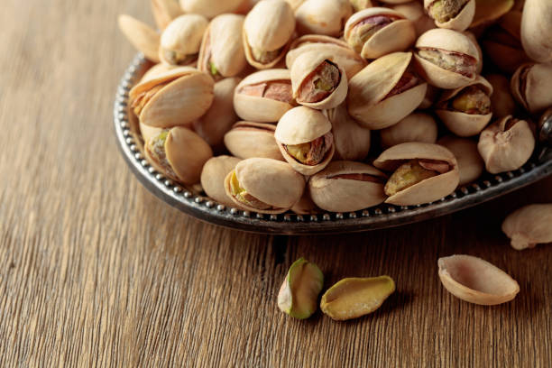 istock Salted pistachios on an old wooden table. 2204089211