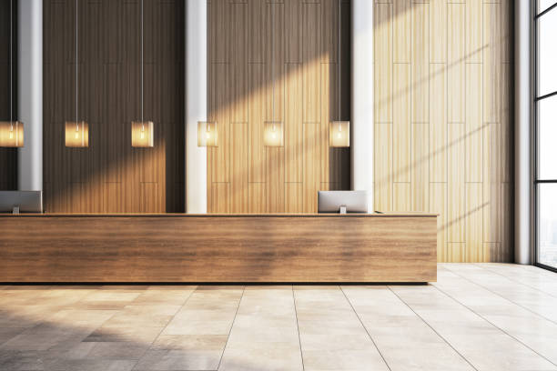 istock Modern hotel reception desk in a spacious lobby with wooden panel walls and pendant lighting. 3D Rendering 2204099272