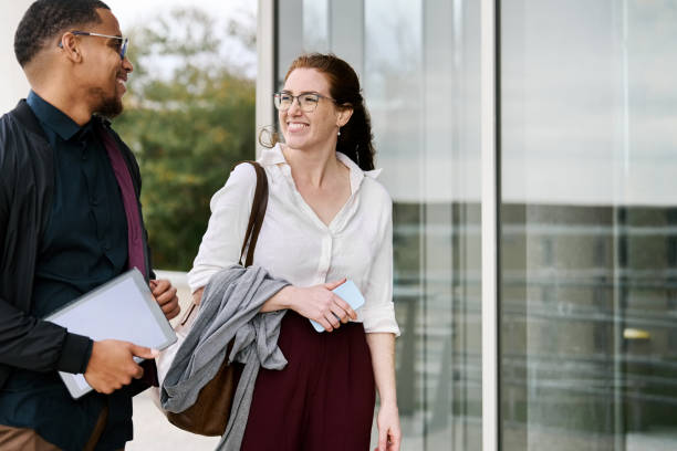 istock Happy business professionals conversing while walking outside office 2204100881