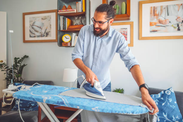 istock Young man ironing his shirt 2204101942