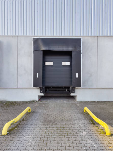 istock A loading dock with a closed black industrial garage door, surrounded by a weathered dock shelter. 2204101953