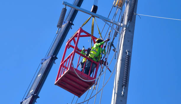 istock Men in work clothes and hard hats are installing high-voltage wires on a power pole 2204105746