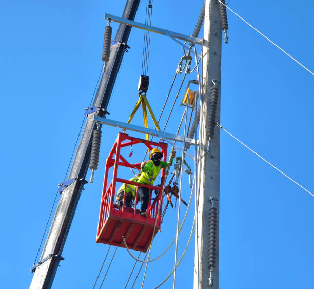 istock Men in work clothes and hard hats are installing high-voltage wires on a power pole 2204105812