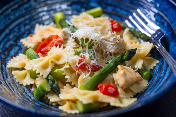 istock Farfalle pasta with green asparagus, cherry tomatoes and chicken 2204106001