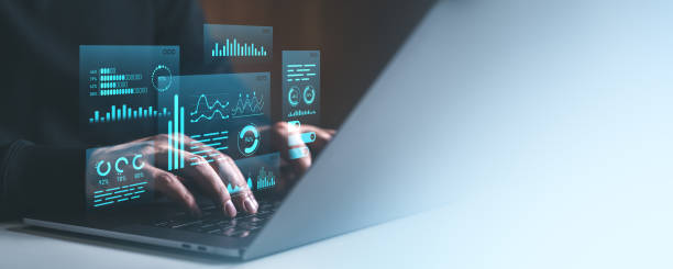istock Cyber data analytics concept with hands typing on laptop and futuristic blue digital graphs on transparent screen in tech workspace. 2204113080