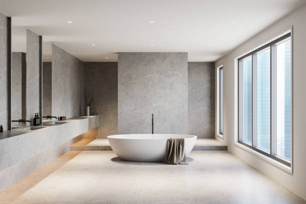 istock Modern minimalist bathroom interior with freestanding bathtub, large windows, and sleek concrete accents. 3D Rendering 2204114325
