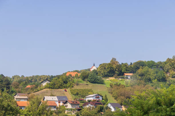 Aerial view of a rural village with fields and hills.