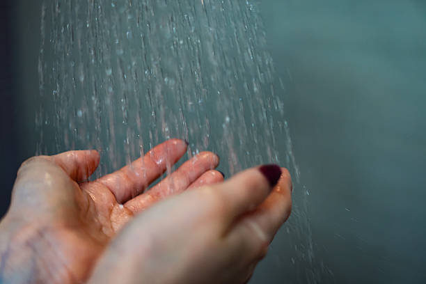 istock Hands Under Flowing Water in a Bathroom Shower 2204119940