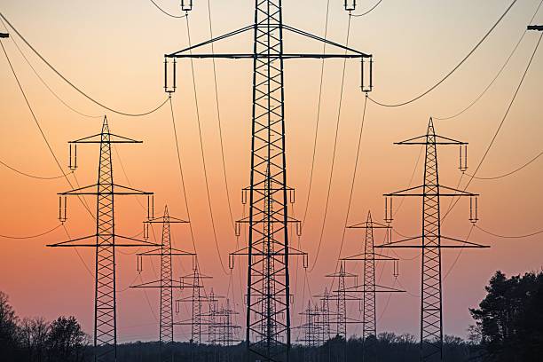 istock High voltage power lines over a field at sunset 2204120146