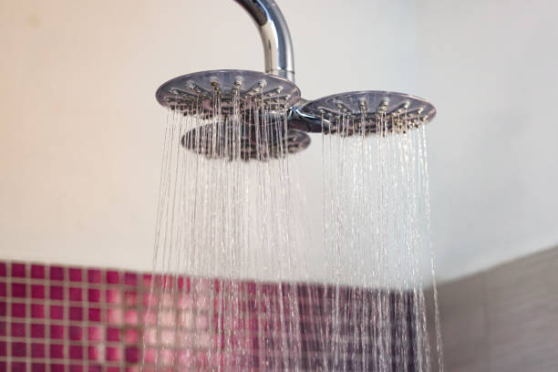 istock Dual Shower Head with Flowing Water in a Modern Tiled Bathroom 2204120864