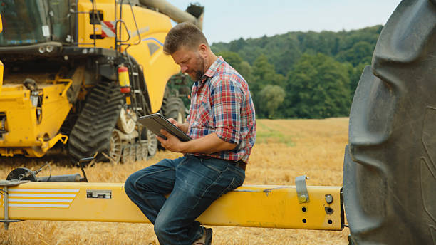 istock Farmer with Digital Tablet in Harvest Field 2204121650