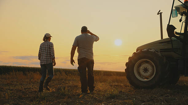 istock Farmers and Tractor at Sunset,End of a Workday 2204122685