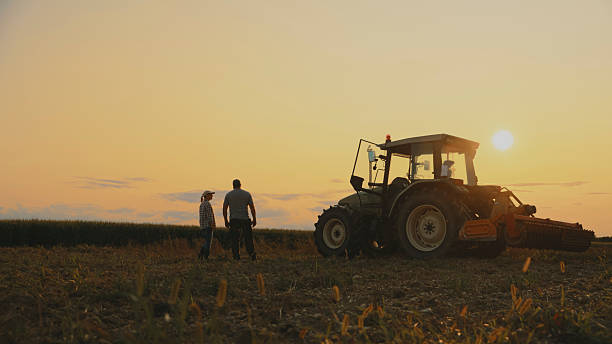 istock Farmers and Tractor in Golden Hour Light 2204122697