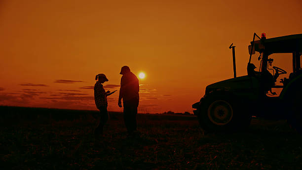 istock Farmers Reviewing Data at Sunset 2204122701