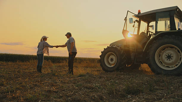 istock Farmers Shaking Hands by Tractor 2204122703