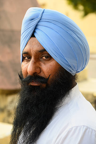 Jaipur, Rajasthan, India - February 17 2025: Portrait of a Sikh Man Wearing Blue Dastar Turban with Long Black Beard.