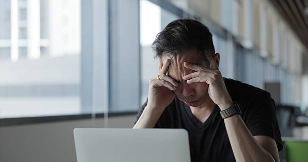 istock Asian businessman burn out on failed job in office. Elderly office worker expresses emotions Failed to work No success. Financial Communication Business problem. Working too hard overtime 2204137902