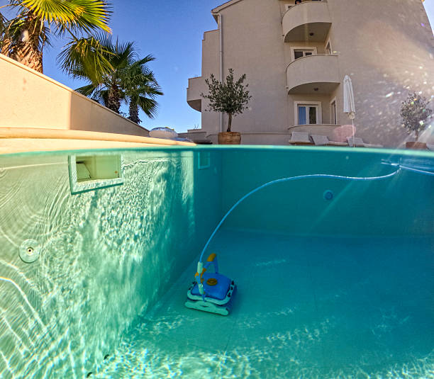 istock Split View of Modern Villa Pool with Cleaning Robot and Palm Trees in Bright Daylight 2204137927