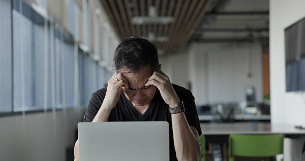 istock Asian businessman burn out on failed job in office. Elderly office worker expresses emotions Failed to work No success. Financial Communication Business problem. Working too hard overtime 2204137951
