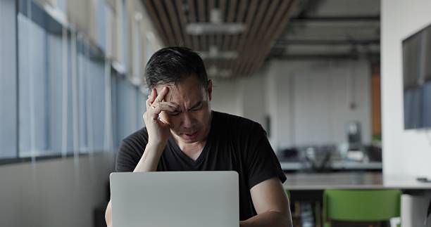 istock Asian businessman burn out on failed job in office. Elderly office worker expresses emotions Failed to work No success. Financial Communication Business problem. Working too hard overtime 2204137970