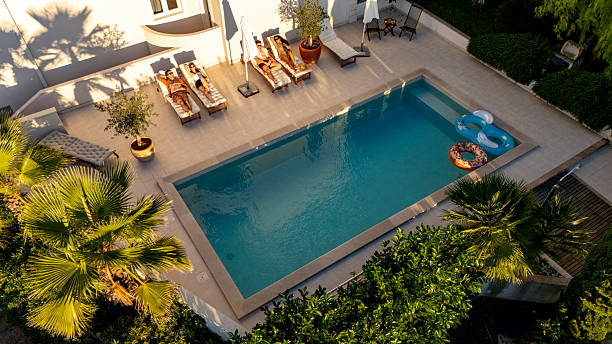 istock Diverse Friends Relaxing by a Serene Pool at Sunset with Lush Greenery and Warm Light 2204138031