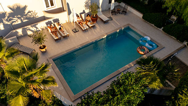istock Diverse Young Friends Relaxing by a Luxurious Poolside at Sunset in a Serene Outdoor Setting 2204138035