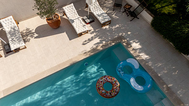 istock Sunny Poolside with Inflatable Rings and Lounge Chairs at Serene Vacation Rental 2204138041