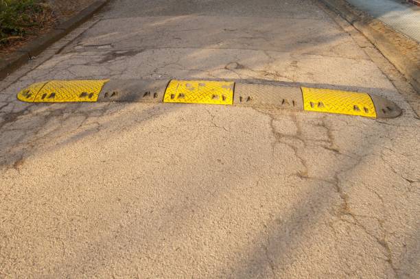 istock Speed bump reducing traffic speed on asphalt road 2204146009