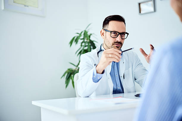 istock Male Doctor Engaging in a Consultative Discussion in a Bright Office 2204147134