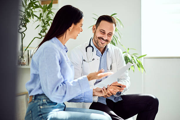 istock Doctor Consulting with Patient in Bright Clinic Environment 2204147708