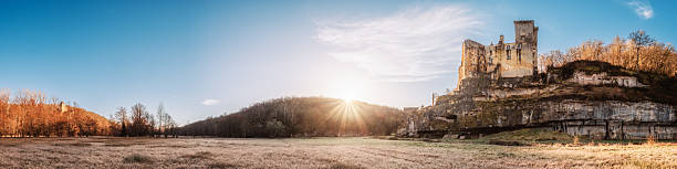 Eyzies, Dordogne, France - 5th March 2025: Panoramic view of sun rising on the ruins of the medieval 12th century Chateau de Commarque in the Dordogne region of France with Chateau de Laussel in th distance