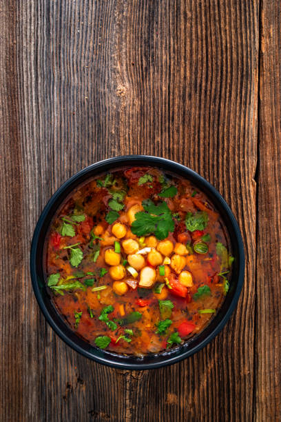 istock Fresh vegetable soup with chick-pea served in white bowl on wooden table 2204149825