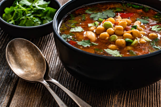 istock Fresh vegetable soup with chick-pea served in white bowl on wooden table 2204149952