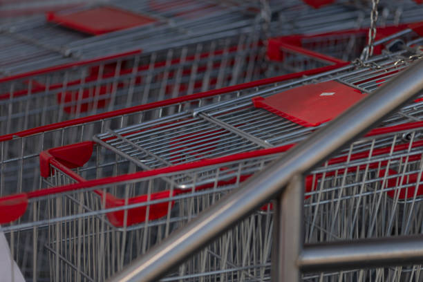 A neat row of shopping carts featuring vibrant red handles is organized for easy access and utilization at your local store entrance