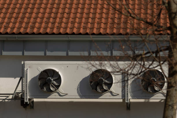 A charming building with a red tile roof and three side fans