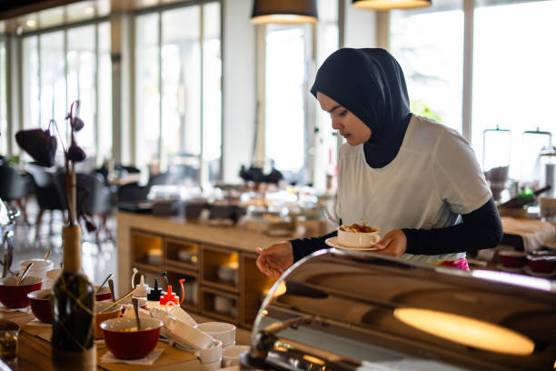 istock Muslim woman at hotel restaurant buffet 2204158332