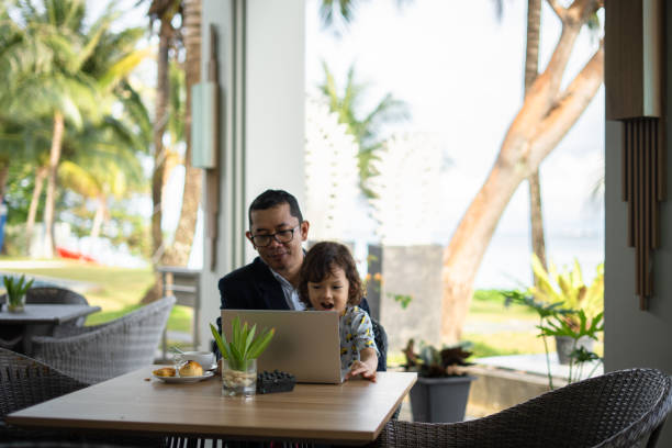 istock Affectionate single father and his small son during meal breakfast  at the hotel table 2204158408