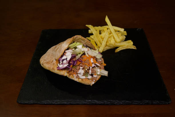 istock A wrap with a side of fries on a black plate 2204164010